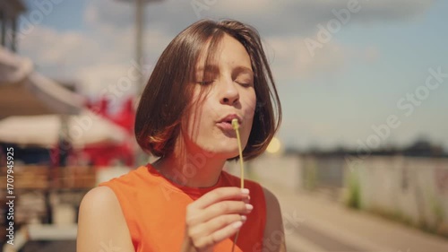 Childhood joy and nature: adorable girl blowing dandelion in summer