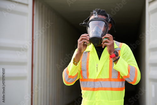 Photography Worker wearing a respirator mask and safety vest, set inside a cargo container