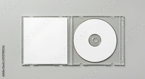 dvd case and cd, Open clear plastic CD jewel case with blank white disc and insert for branding. Mock-up of compact disc packaging on soft gray background. Represents digital storage, music or softwar