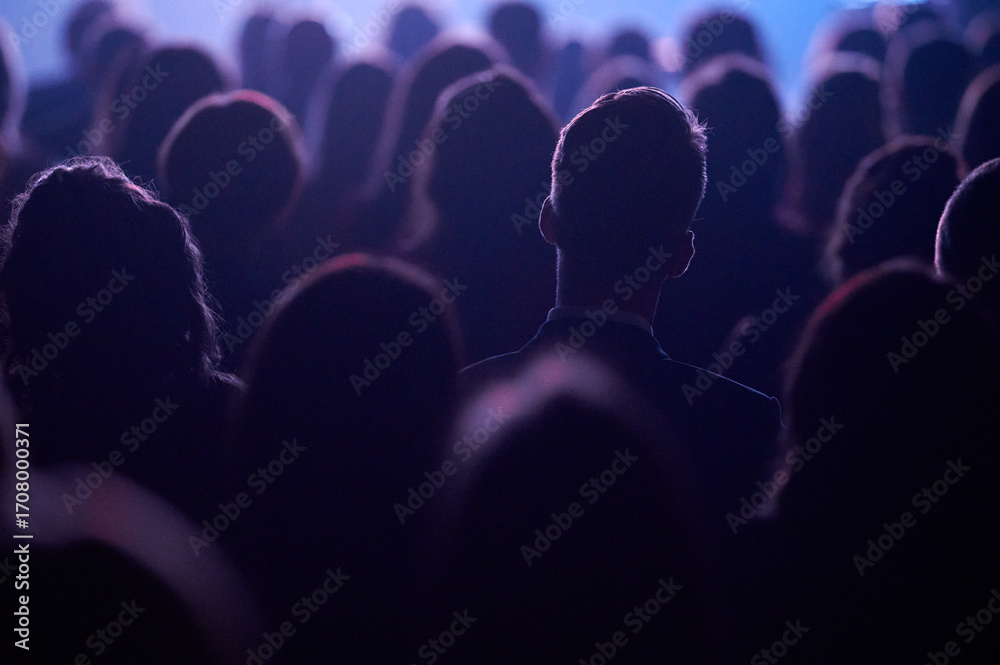 Obraz premium Head silhouette framing bright screen at Gdynia tech talk, blue violet rim light, landscape telephoto, shallow depth, dynamic mood, promo for innovation forum