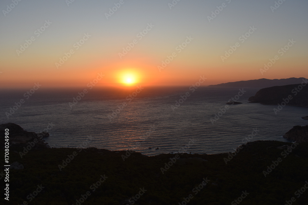 Fototapeta premium Sunset at Monolithos castle, Rhodes island, Greece. Sightseeing spots on Rhodos. View from the ruin Monolithos Castle. Holidays and travel to Rhodes Island. Rhodes seascapes and nature. 