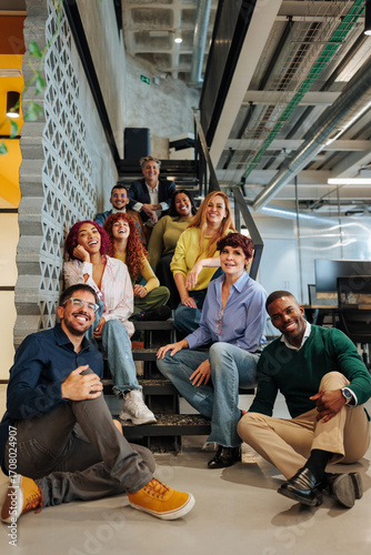Diverse business team smiling and relaxing on office stairs