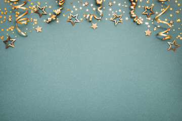 New Year, Christmas or birthday festive background top view. Celebration composition with golden confetti stars and serpentine party streamers.