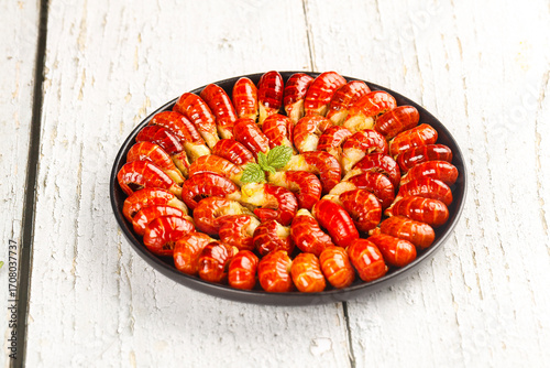 Fresh Cooked Qianjiang Crayfish with Red Shells and Tails Arranged in Black Plate on Rustic White Wooden Background