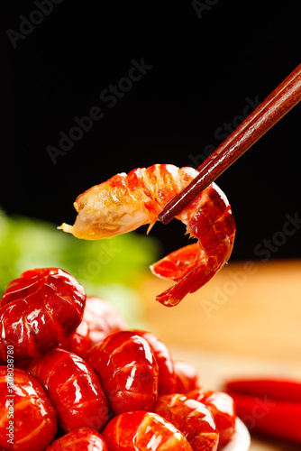 Fresh Cooked Crayfish Tail Being Picked Up with Chopsticks Showing Yellow Orange Meat