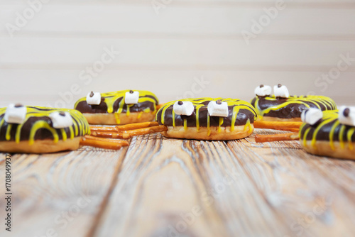 Spider-themed chocolate donuts on rustic wooden surface