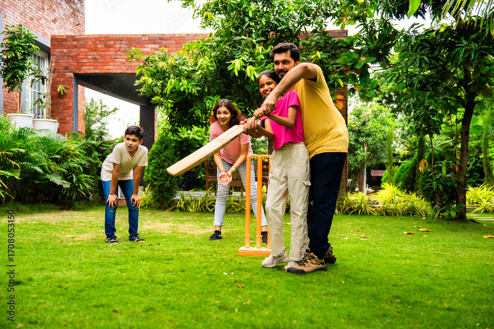 Fototapeta premium Indian Asian family bonding through outdoor cricket batting in garden, enjoying fun and play
