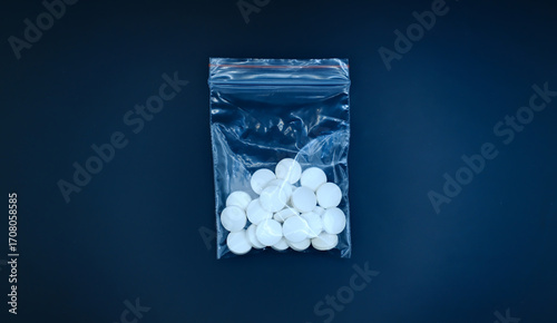 Photography drug pills in plastic packet on a black background