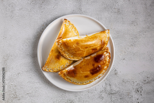 Stuffed empanadas on a plate on the table. Argentine empanadas.