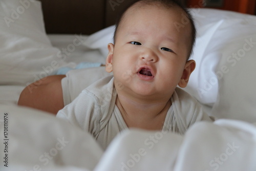 Adorable baby doing tummy time on the bed