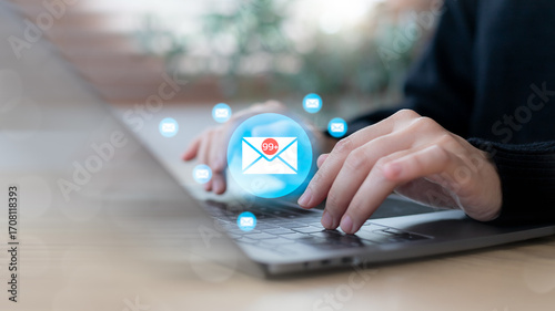 Photos Hands typing on a laptop with email icons and inbox notification 99, symbolizing digital communication overload, work stress, business email management, productivity challenge, and office workflow