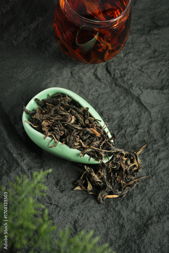 Fototapeta premium Organic Mountain Tea Leaves with Brewed Cup - Premium Plantation Tea on Dark Slate Background