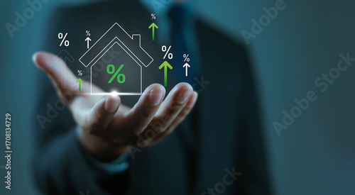 Businessman holding house icon with rising percentage signs, symbolizing real estate growth, property investment, mortgage rates, housing market, financial success, home value, economic development.