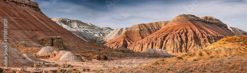 Photography Panoramic view of colorful mountains rising from dry desert landscape under clou