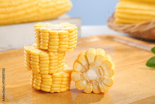 Fresh Sweet Yellow Corn Cob Slices on Wooden Cutting Board