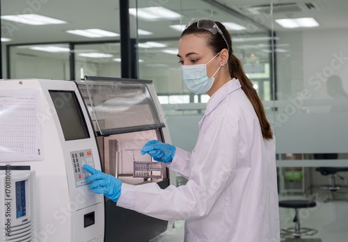 Wallpaper Mural Lab technician operates advanced medical equipment while wearing protective gear in a clean, modern workspace Torontodigital.ca