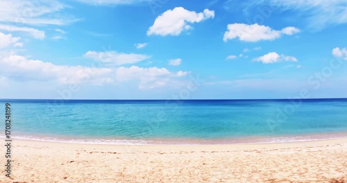 Summer sea background.Blue sky white clouds over ocean waves break on sand beach.Waves crashing against an empty beach.Sea waves and beautiful sand beach in Patong Phuket Thailand. High quality video