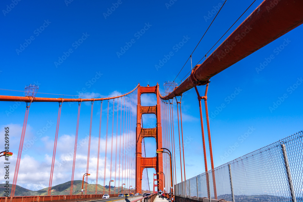 Fototapeta premium Golden Gate Bridge pedestrian walkway with red cables and blue sky