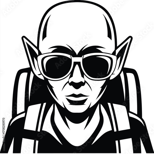 Bald man with pointy ears wearing glasses poses in a chair looking forward