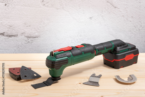 Electric multi-tool on wooden background