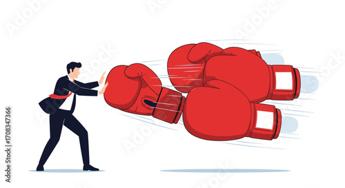 Business man facing giant boxing gloves head on.