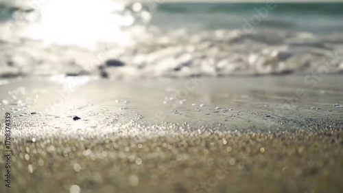 A Gentle Wave Washes Over Wet Sand on a Sun-Drenched Beach, Creating a Calm and Serene Coastal Scene