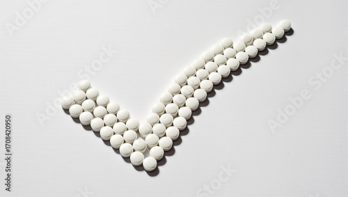 White tablets arranged in a check mark symbolize health and wellness