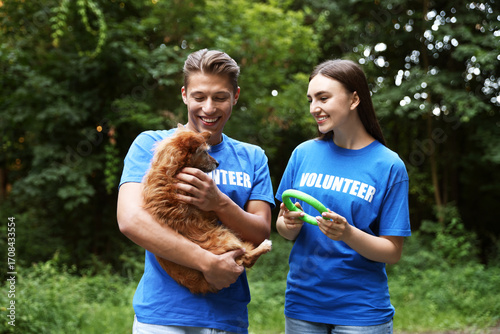 Quadro su tela Volunteers with cute stray dog and toy outdoors. Animal rescue