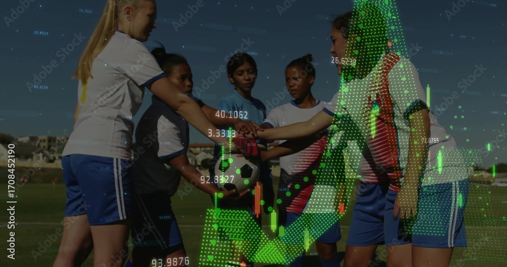 Fototapeta premium Huddling soccer players wearing jerseys stacking hands over ball on grass field, with chart overlay