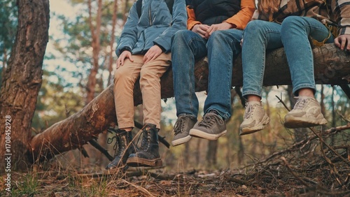 teenagers hikers tourists sit on a tree in the forest park. travel team business freedom concept. shoes close-up feet sitting on a tree in the forest lifestyle park