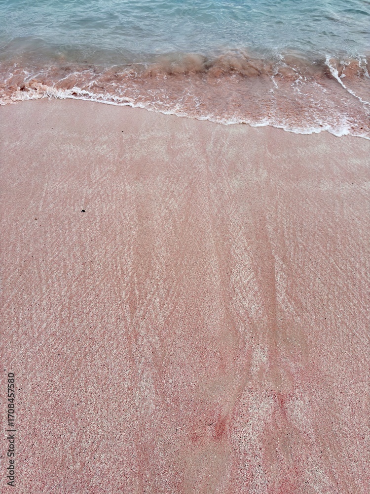 Fototapeta premium Serene pink sand beach kissed by gentle turquoise waves perfect for vacation vibes, tropical getaways, and calming coastal scenes