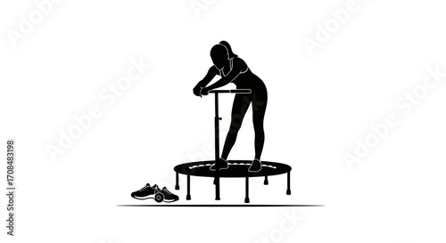 Silhouette of athletic woman resting on mini trampoline after intense workout session