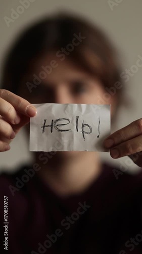 A Woman Seeking Help. A Card Inscription and a Scared Girl. A woman is holding a card with the words help. domestic violence concept. mental health, abuse. Stop the Abuse