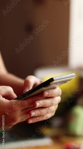 A Woman Hand Texting on a Smartphone, vertical close up view. Close-up of a Hand Typing on a Smartphone. A Woman Using a Messaging App on a Smartphone