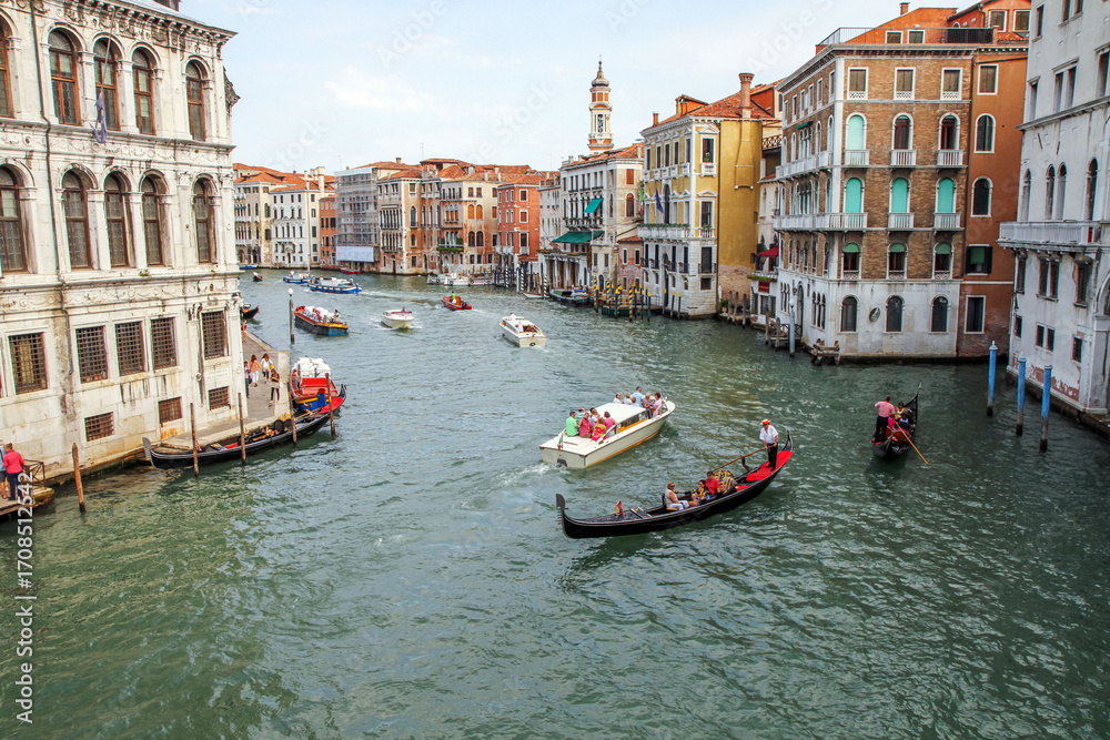 Obraz premium Scenic view of Grand Canal in Venice, Italy, with gondolas, boats and historic architecture. Popular tourist destination and romantic cityscape.