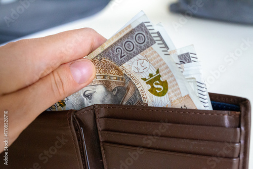 Tableau sur toile Hand pulling Polish złoty banknotes from wallet