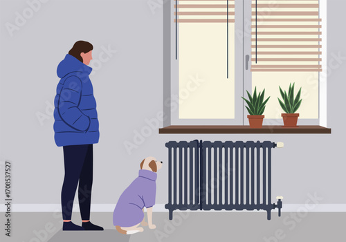 A woman in a blue puffer jacket stands next to a dog wearing a purple sweater in a room with a radiator and a window with plants, creating a cozy and warm indoor scene, showcasing winter attire