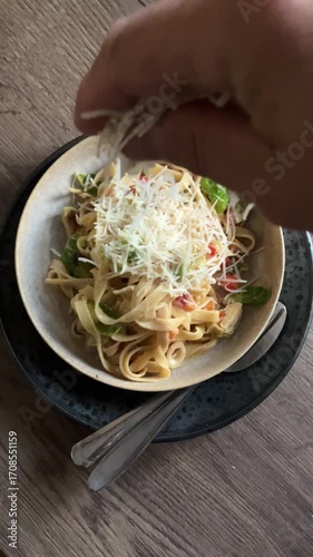 Tagliatelle pasta served with fresh vegetables on a plate, colorful Italian dish on rustic wooden background. Traditional Mediterranean cuisine, healthy homemade meal