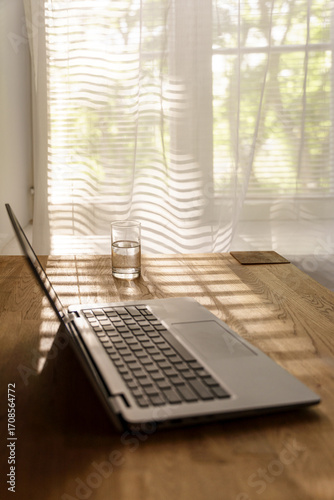Cozy home office aesthetic with warm brown table and laptop, background with copy space