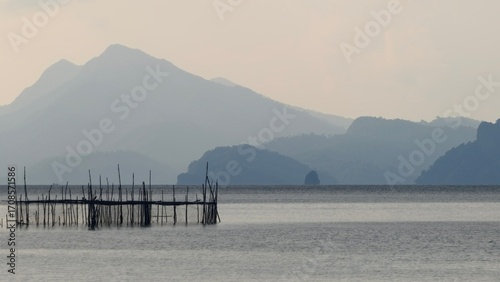 A mountain-backed lagoon with a wooden pier
