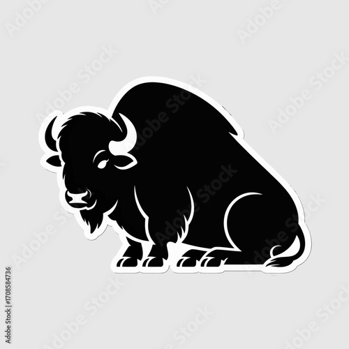 Silhouette of a powerful bison sitting on a plain background