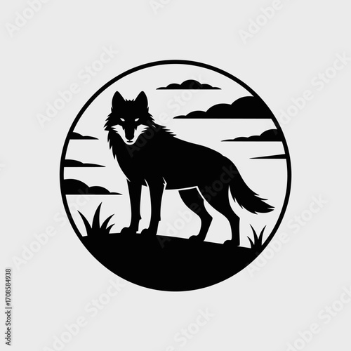 Silhouette of a wolf standing in a circular frame with clouds and grass