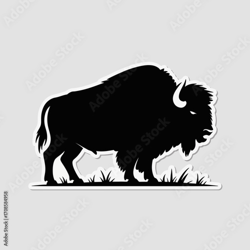 Silhouette of a majestic bison standing in a grassy field