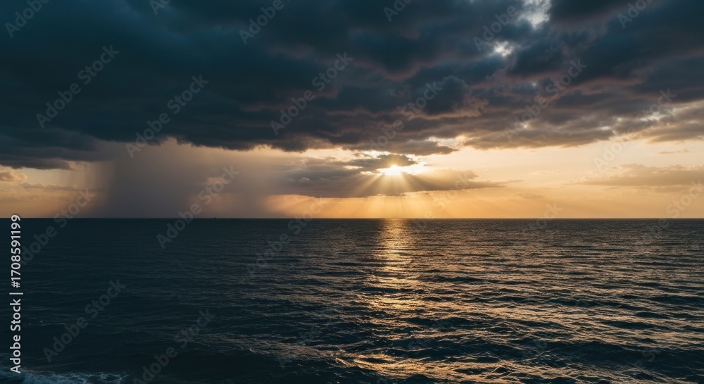 Obraz premium Dramatic sunset over the ocean, with stormy clouds