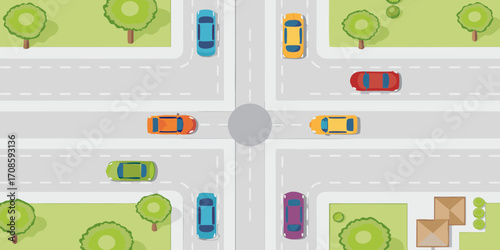 Top down view of a busy intersection with cars driving on the road and trees on the side