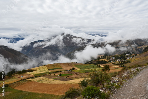 Pequeño pueblo en campos andinos bajo cielo nublado -  Small Village in Andean Fields under a Cloudy Sky