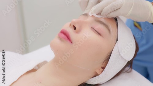 A close-up of a young Asian woman receiving a Botox or dermal filler injection in her face from a professional. Concept for beauty clinics, dermatology, and anti-aging treatments.