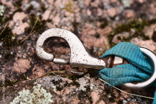 Fotografie A close-up shot of a metal hook stuck in a rock, often used as a prop or symbol