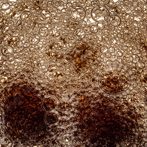 Carbonated beverage bubbles in dark fizzy liquid  