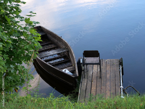 Old Wooden Boat Moored at a Small Dock on a Calm River Background from Top View